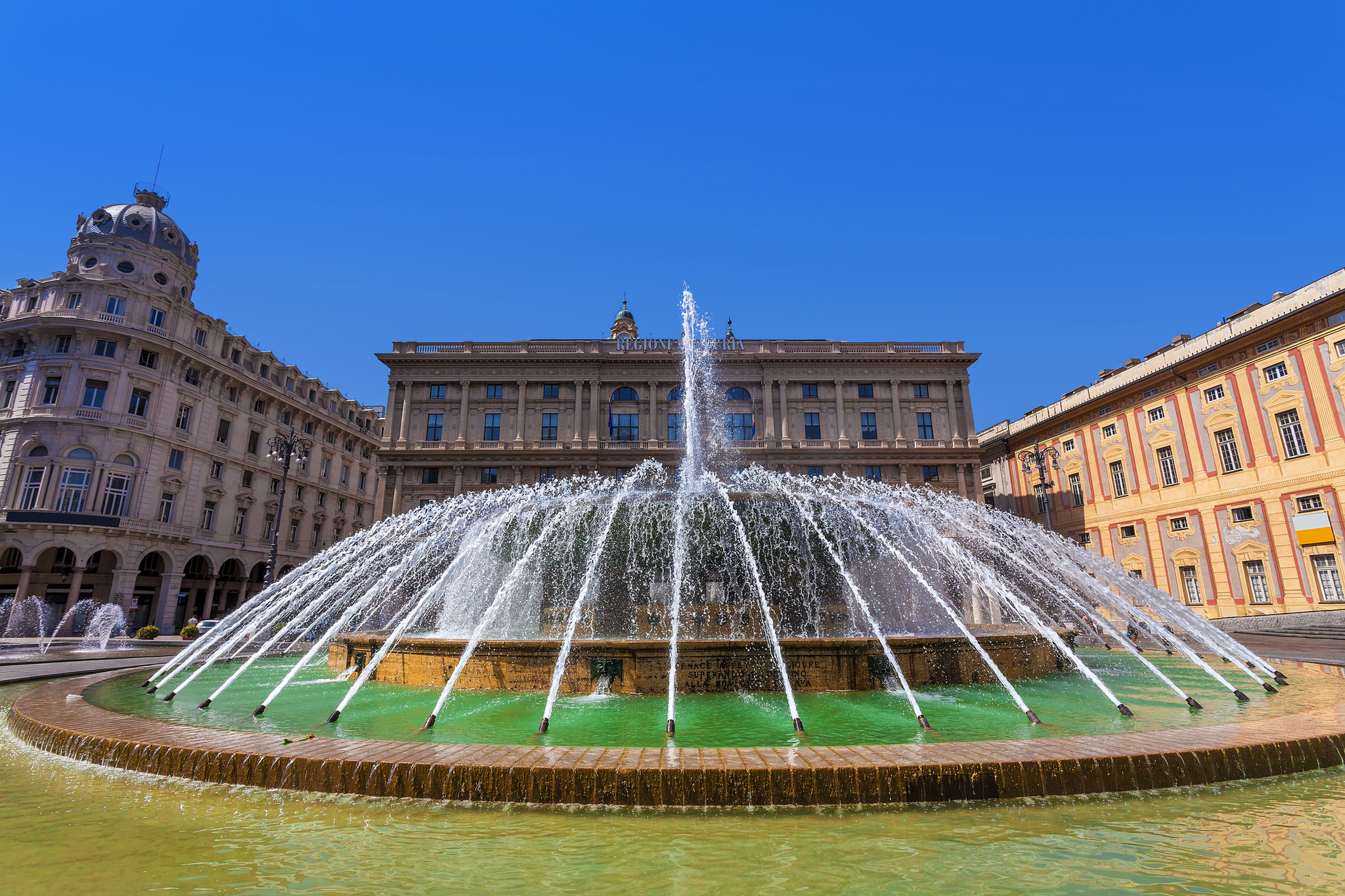 Brunnen auf der Piazza de Ferrari in Genua Großer Springbrunnen auf einem Platz vor historischen Gebäuden.