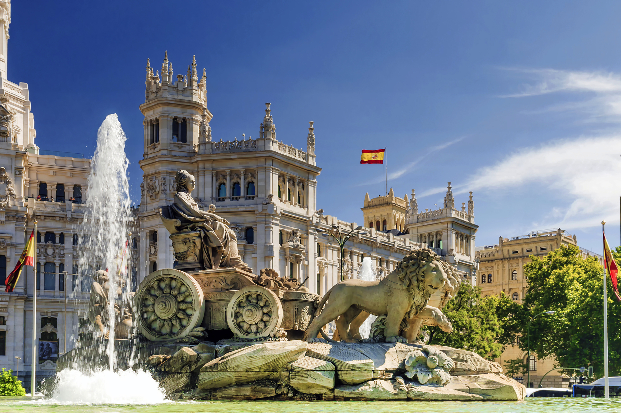 Springbrunnen mit Statue und Gebäude im Hintergrund in Madrid.