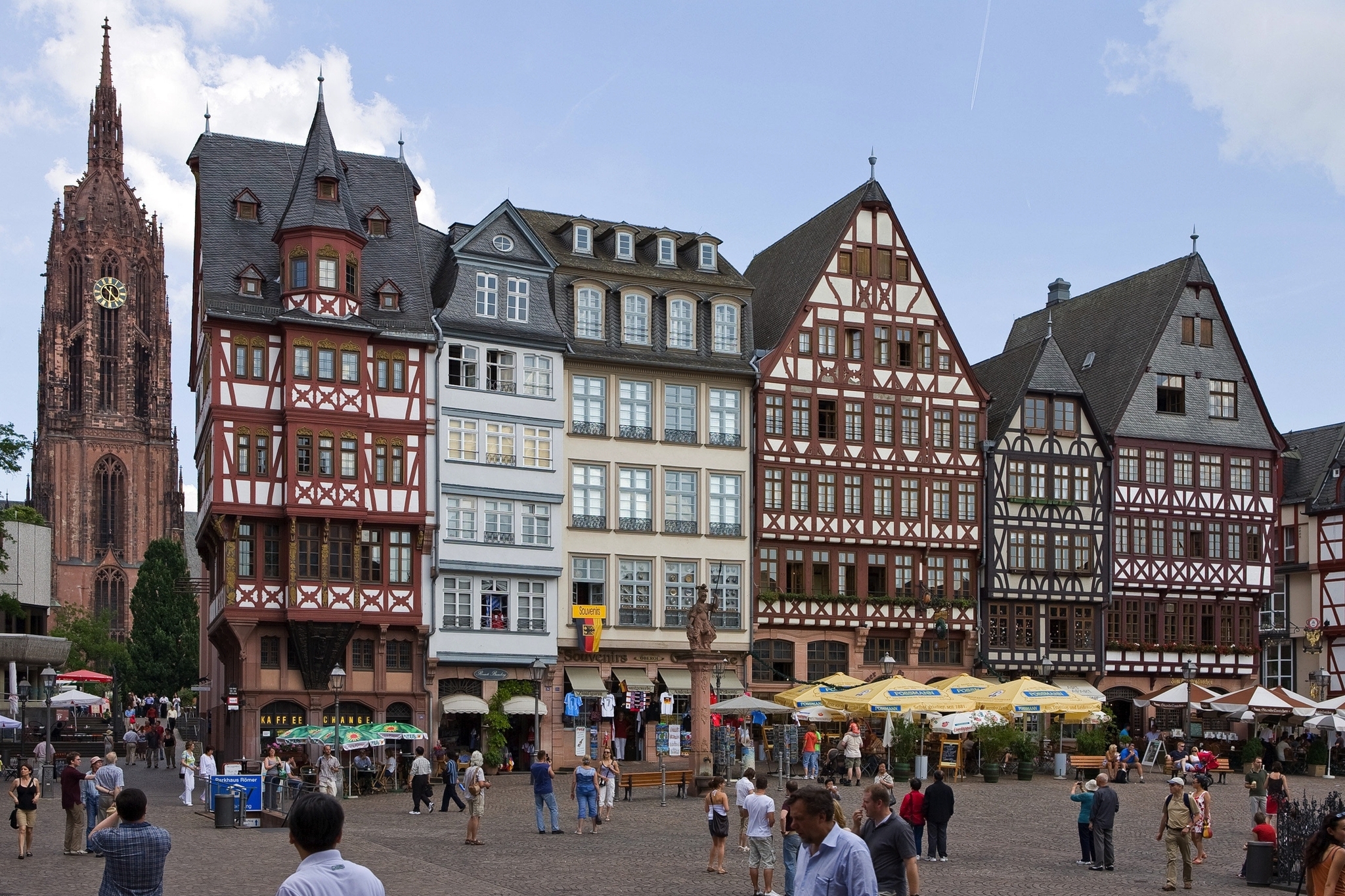 Römerberg in Frankfurt am Main Fachwerkhäuser und ein gotischer Kirchturm auf einem belebten Platz in Frankfurt am Main.