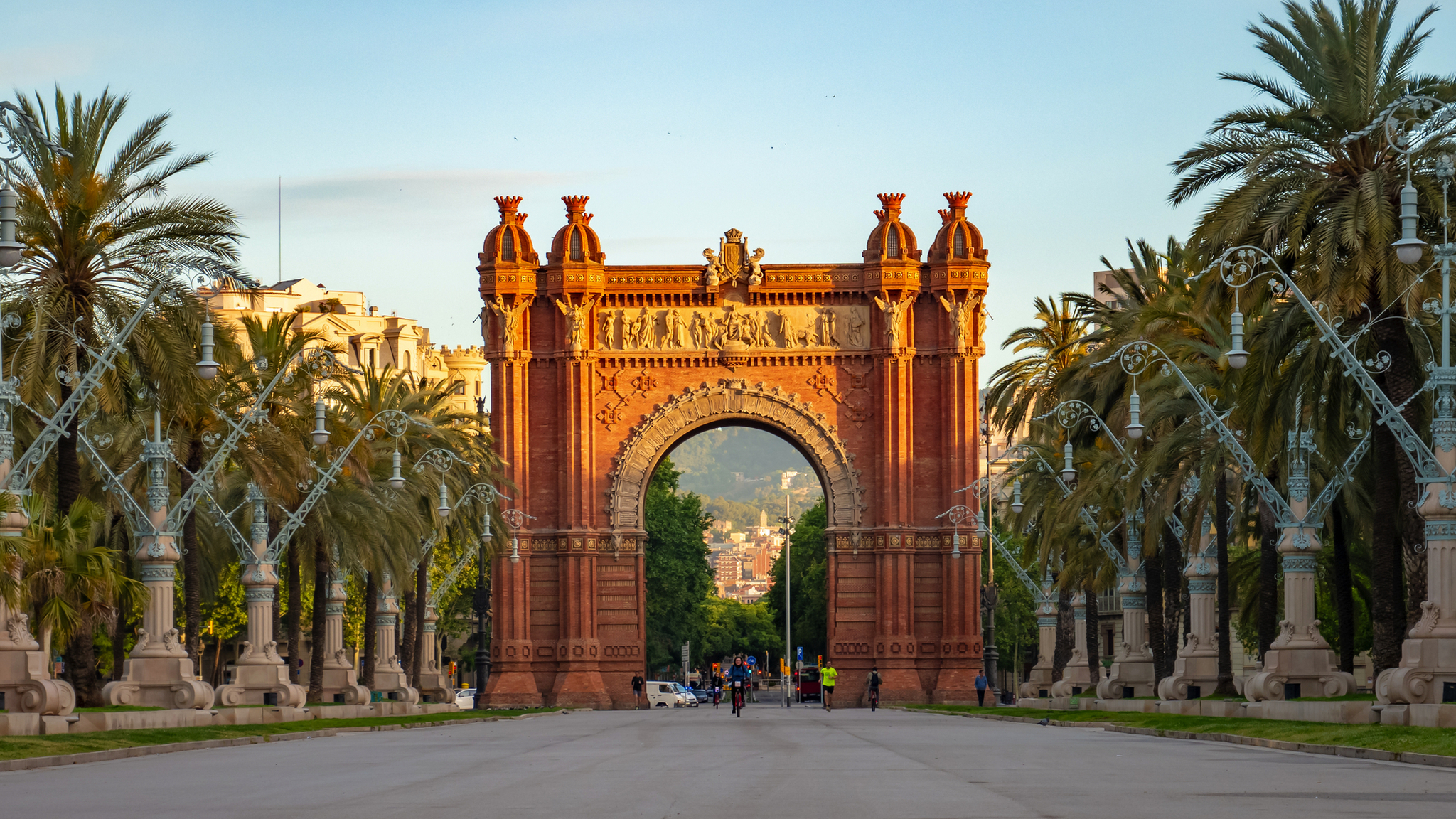 Arc de Triomf in Barcelona Triumphbogen in einer von Palmen gesäumten Promenade unter blauem Himmel in Barcelona, Spanien.