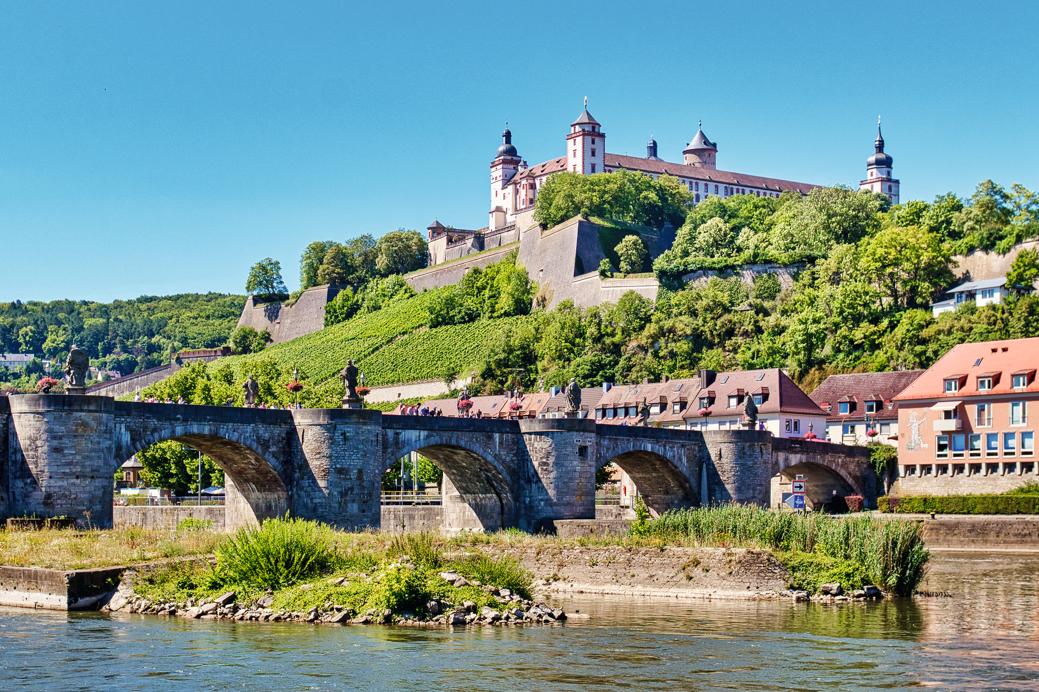 Burg auf einem Hügel über einer Brücke und Fluss, sonniger Tag