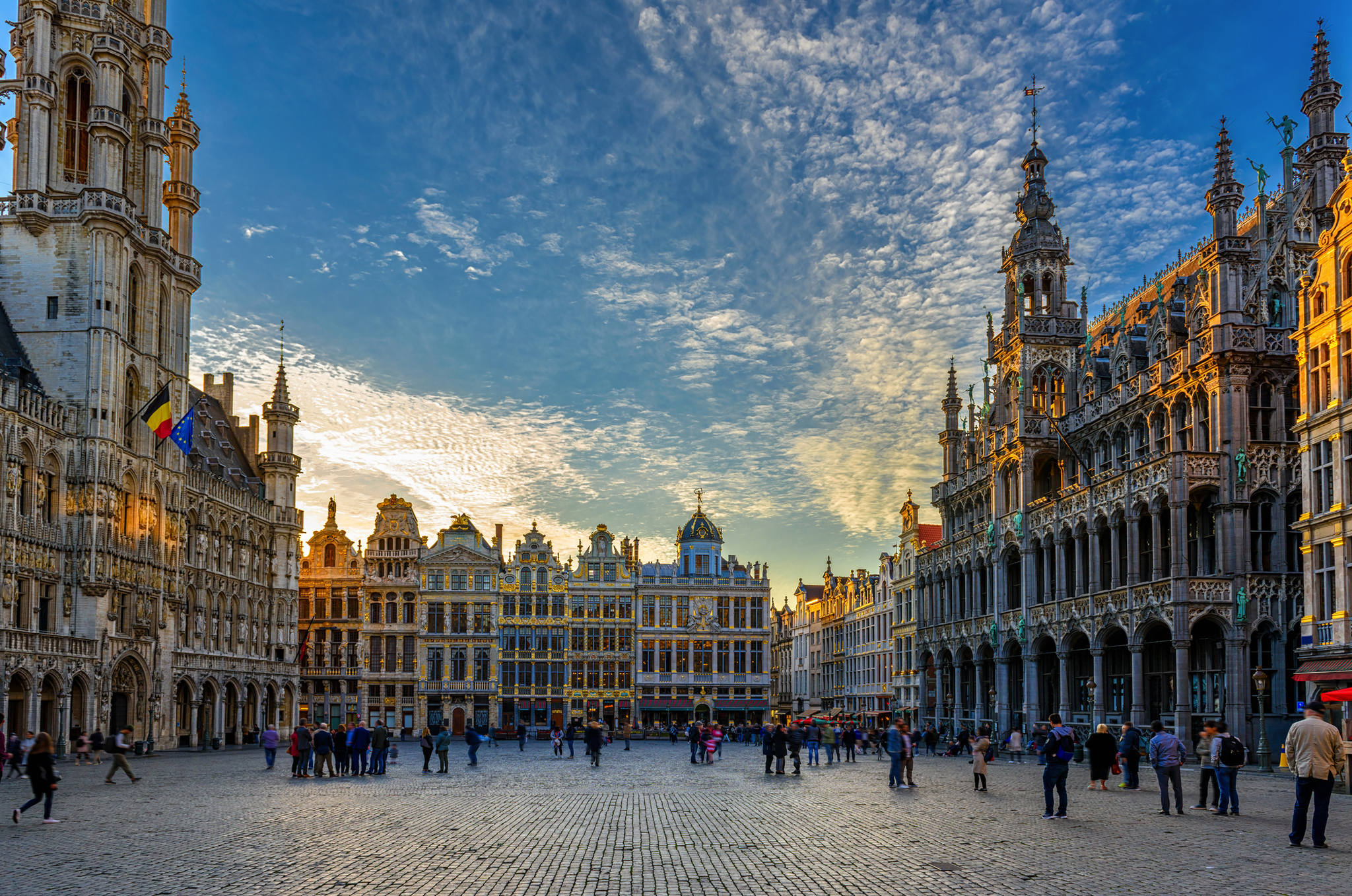 Grote Markt in Brüssel Großer Platz in Brüssel bei Sonnenuntergang mit historischen Gebäuden und Menschen auf dem Platz.