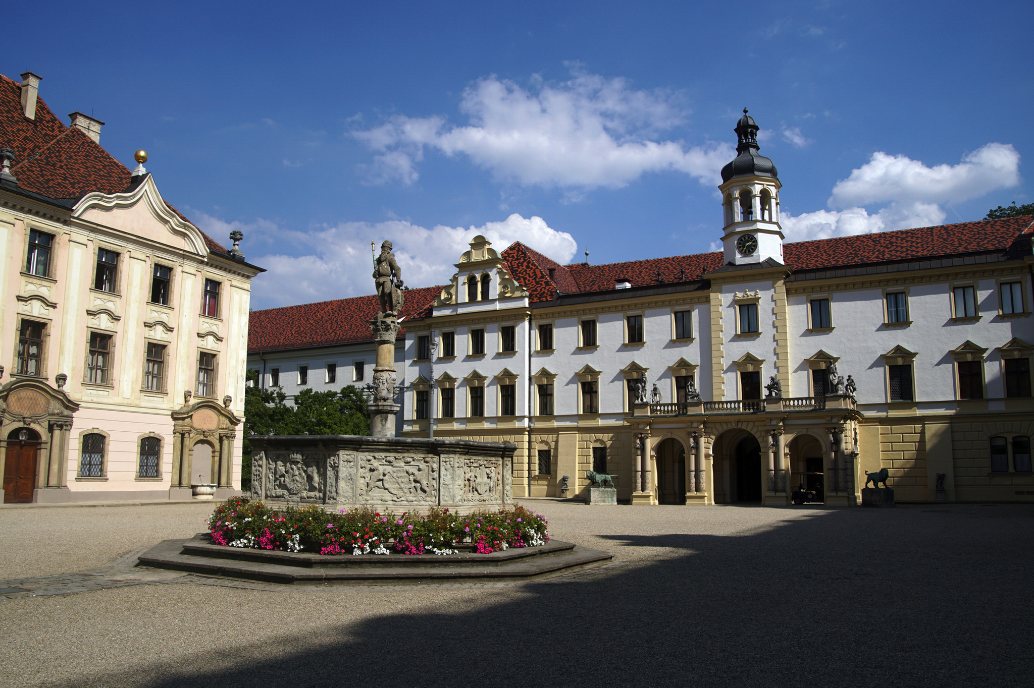 Schloss St. Emmeram oder Schloss Thurn und Taxis in Regensburg Barocker Schlossinnenhof mit Brunnen und Blumenbeet bei sonnigem Wetter.