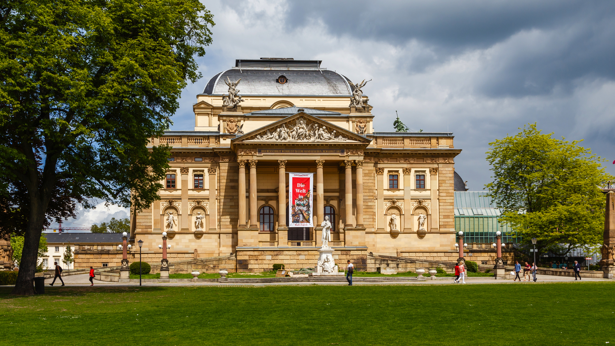 Hessisches Staatstheater Wiesbaden Hessisches Staatstheater Wiesbaden mit beeindruckender neoklassizistischer Architektur, umgeben von Bäumen und besucherfreundlichem Vorplatz.
