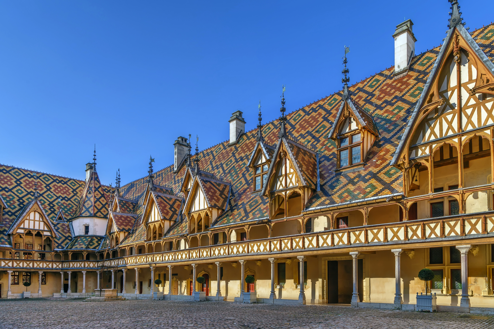Hospices de Beaune in Burgund, Frankreich mit markantem Dachmuster und Innenhof.