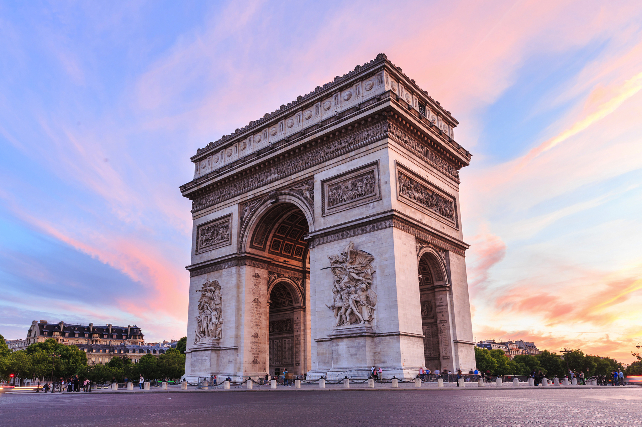 Triumphbogen in Paris bei Sonnenuntergang, mit rosa und blauem Himmel.