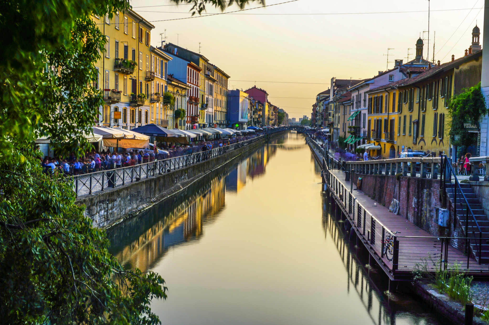 Häuserzeile am Kanal bei Sonnenuntergang mit spiegelndem Wasser.