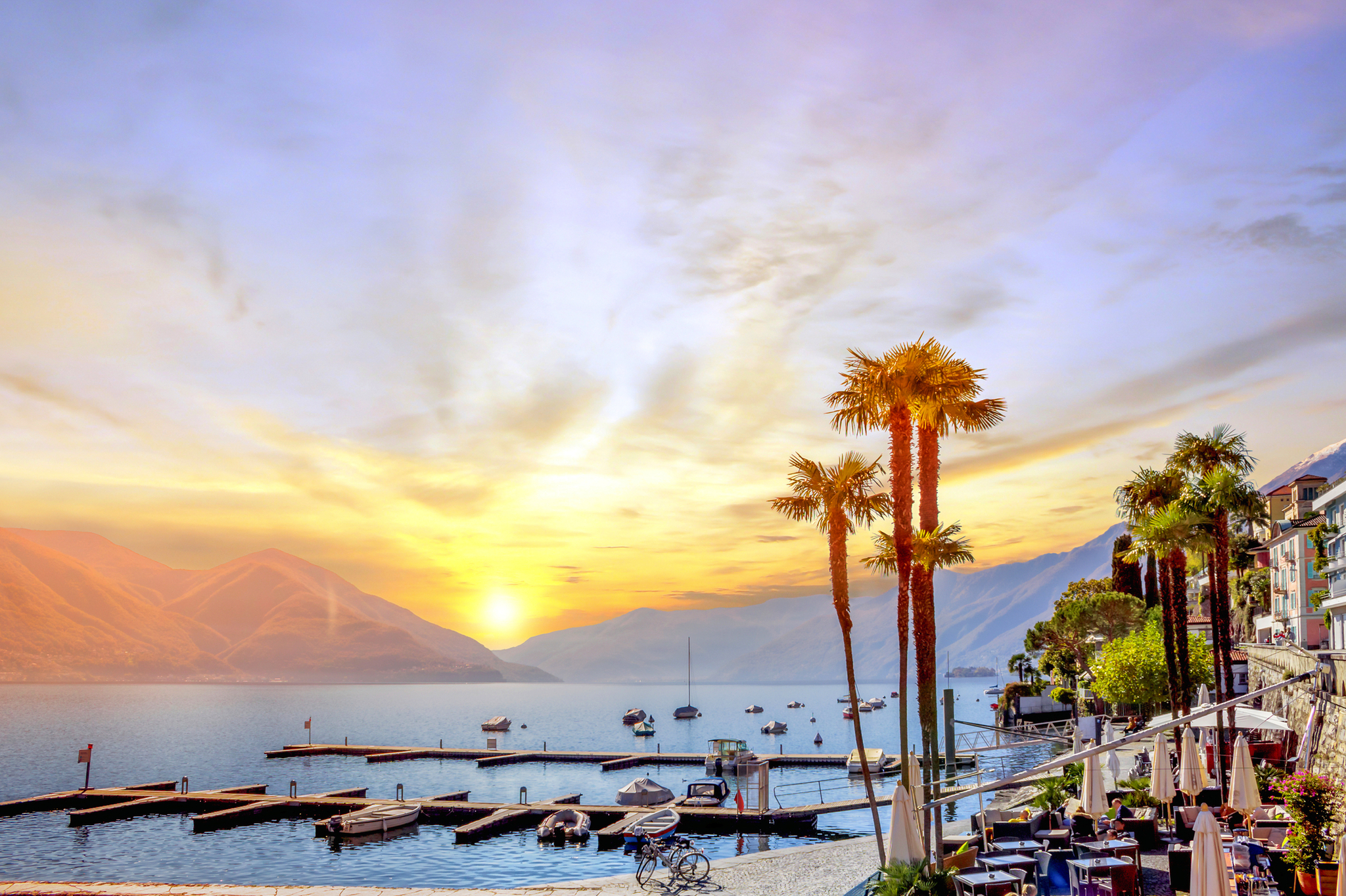 Sonnenuntergang über dem Yachthafen von Ascona am Lago Maggiore im Kanton Tessin, Schweiz.