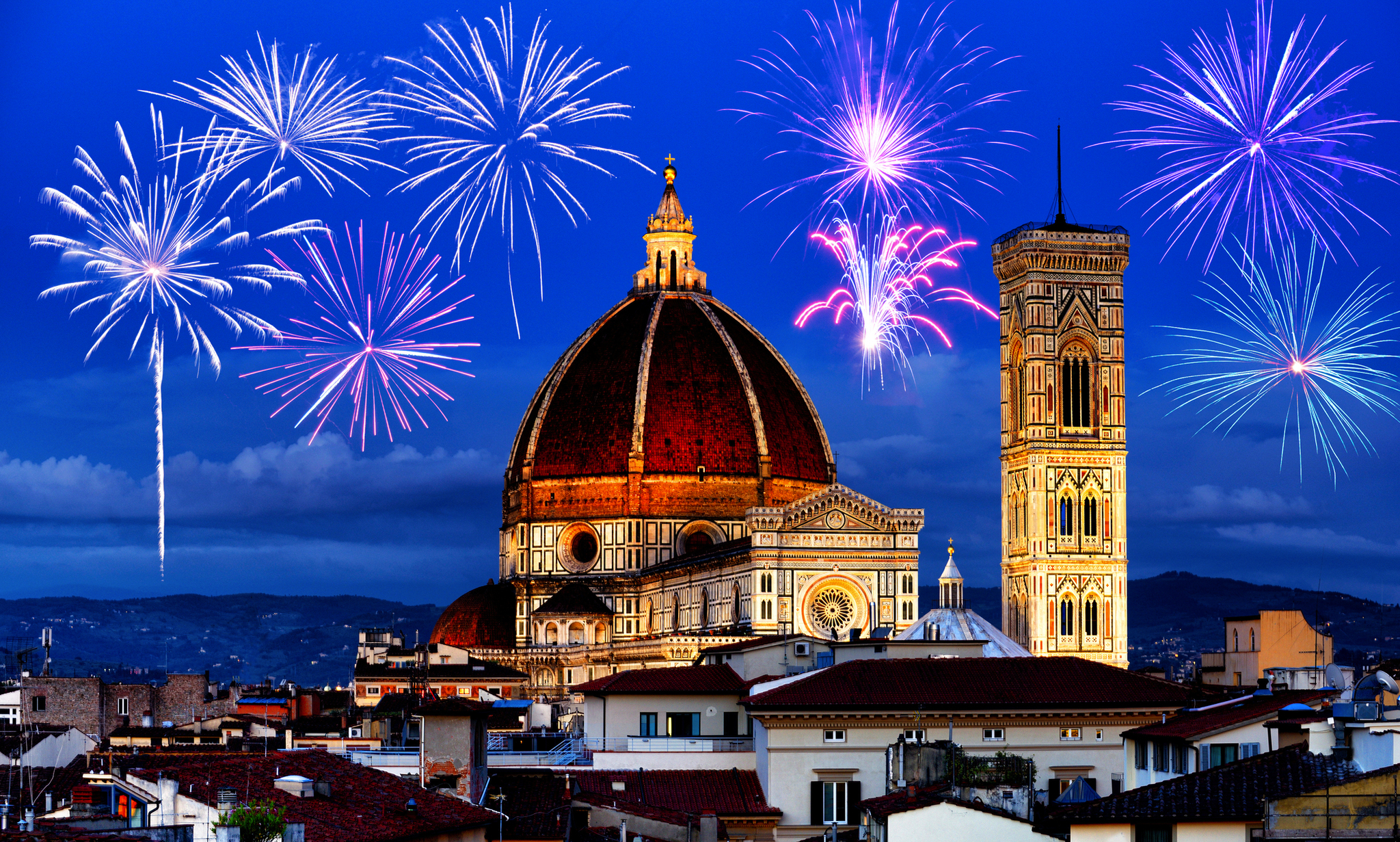 Kathedrale von Florenz bei Nacht mit Feuerwerk im Hintergrund.