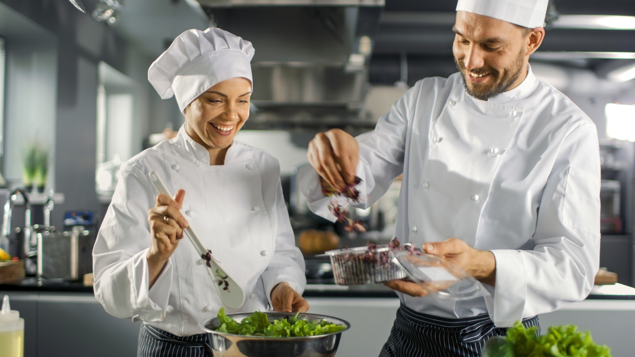 Restaurantküche Zwei Köche bereiten in einer Küche einen Salat zu.