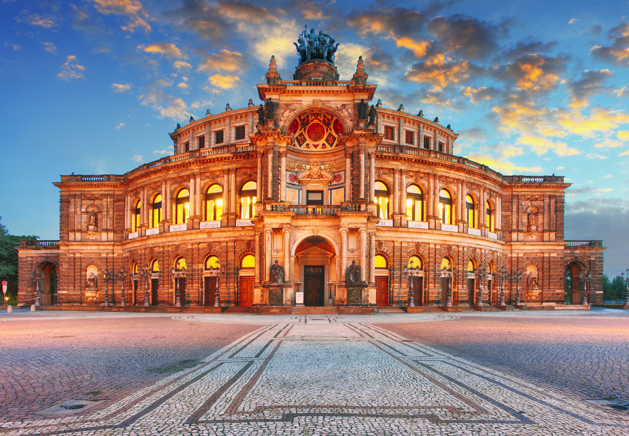 Semperoper Historisches Opernhaus bei Sonnenuntergang mit beleuchteter Fassade.