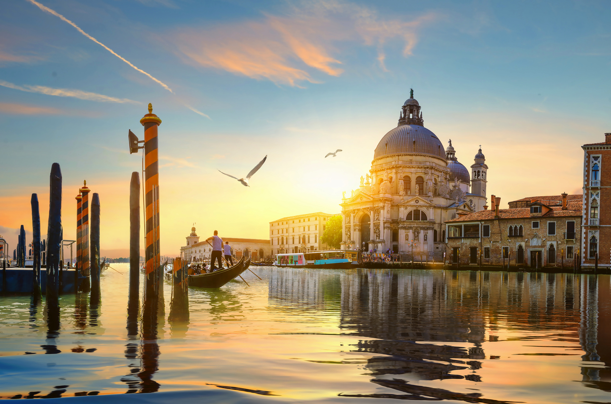 Gondoliere vor Santa Maria della Salute in Venedig Gondel auf dem Canal Grande in Venedig bei Sonnenuntergang, Basilika im Hintergrund.