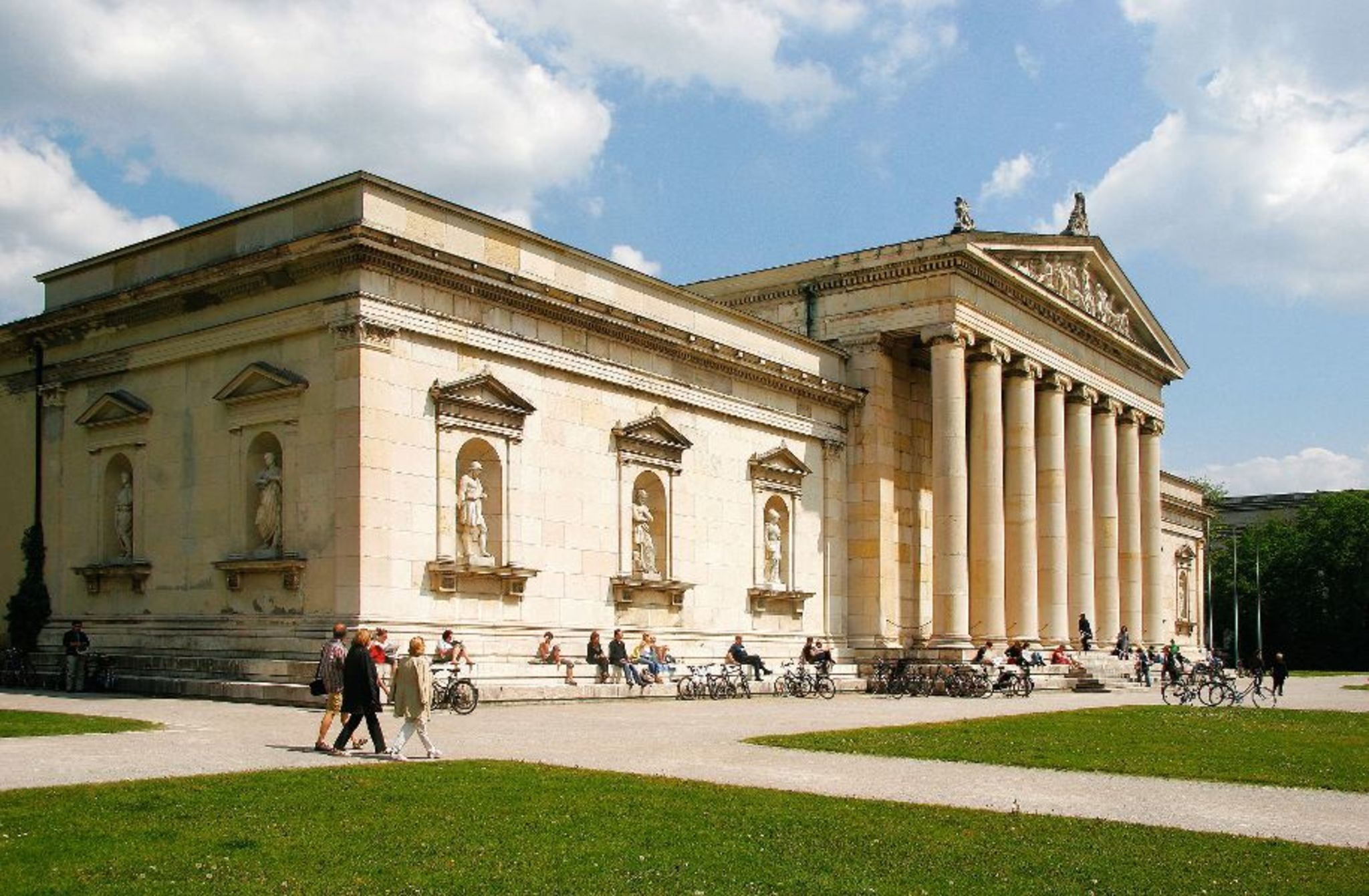 Gebäude der Glyptothek in München mit Parkbesuchern und Säulenfassade.