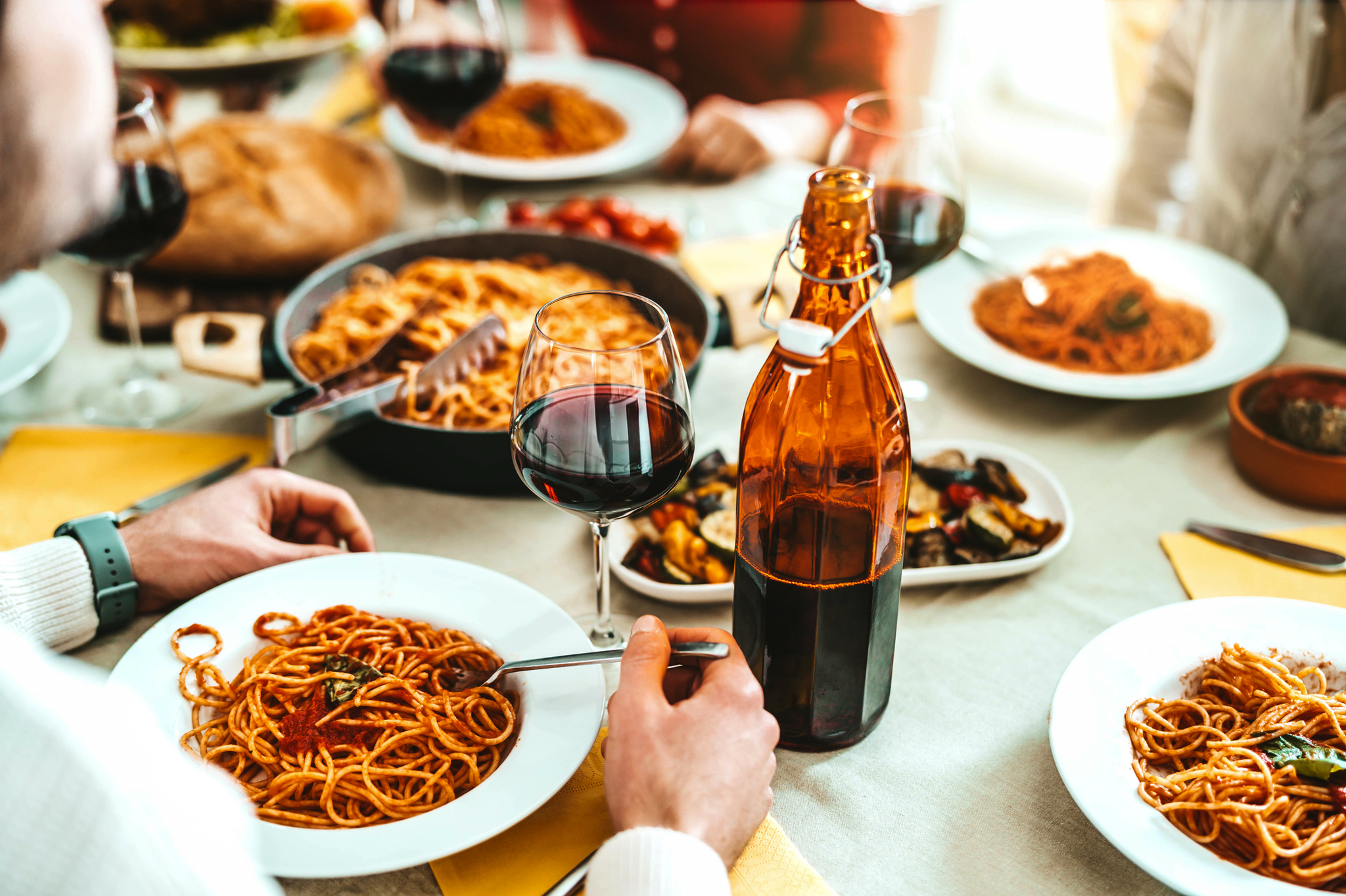 Gruppe von Freunden bei Pasta-Genuss im Restaurant Gruppe von Freunden, die in einem italienischen Restaurant Spaghetti und Rotwein genießen.