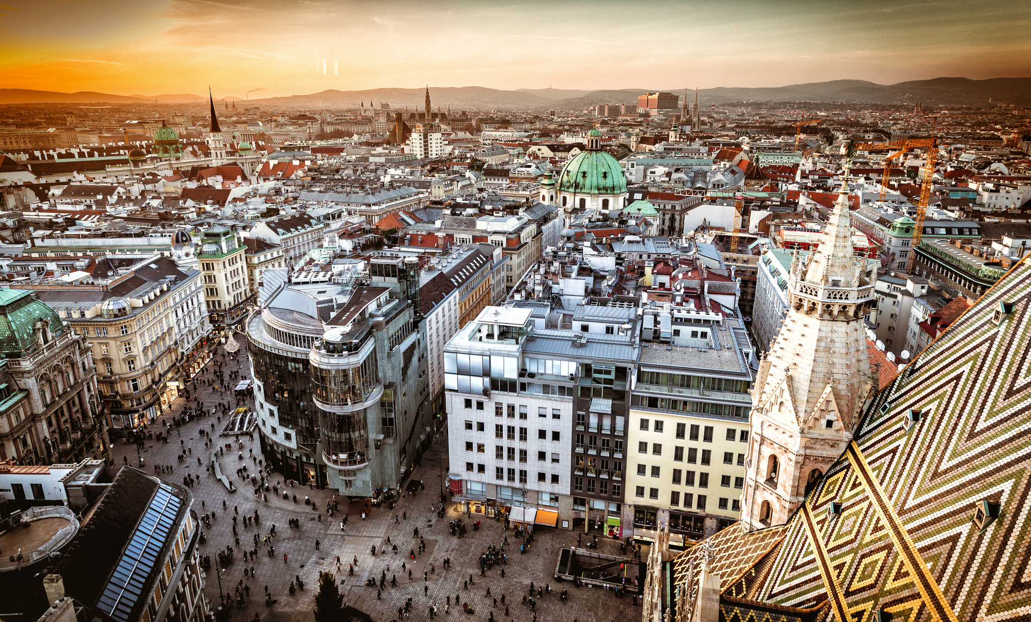 Luftaufnahme von oben auf Wien bei Sonnenuntergang Luftaufnahme von Wien bei Sonnenuntergang, zeigt die Stadtlandschaft mit Gebäuden und Straßen.