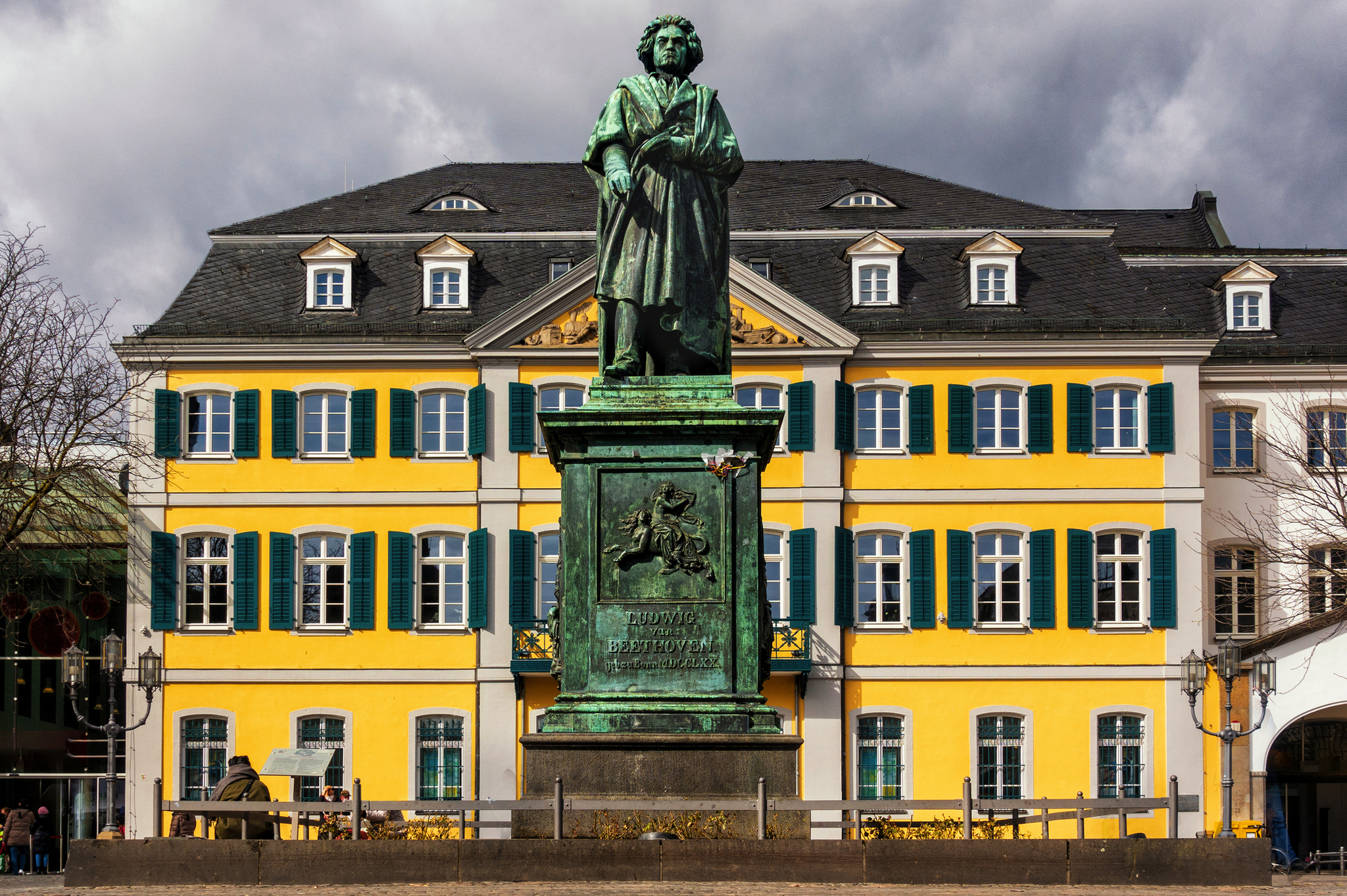 Ludwig van Beethovens Denkmal auf dem Bonner Münsterplatz Ludwig van Beethoven Denkmal auf dem Bonner Münsterplatz im Winter vor einem gelben Gebäude.