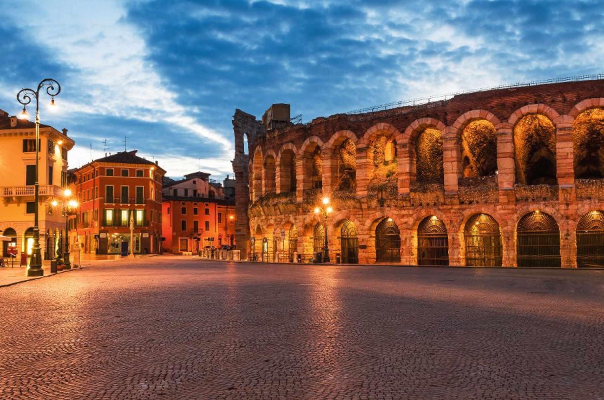 Piazza Bra and Arena, Verona amphitheatre in Italy Blick auf die Piazza Bra in Verona, Italien, mit der historischen Arena im Vordergrund, umgeben von Gebäuden im Abendlicht.