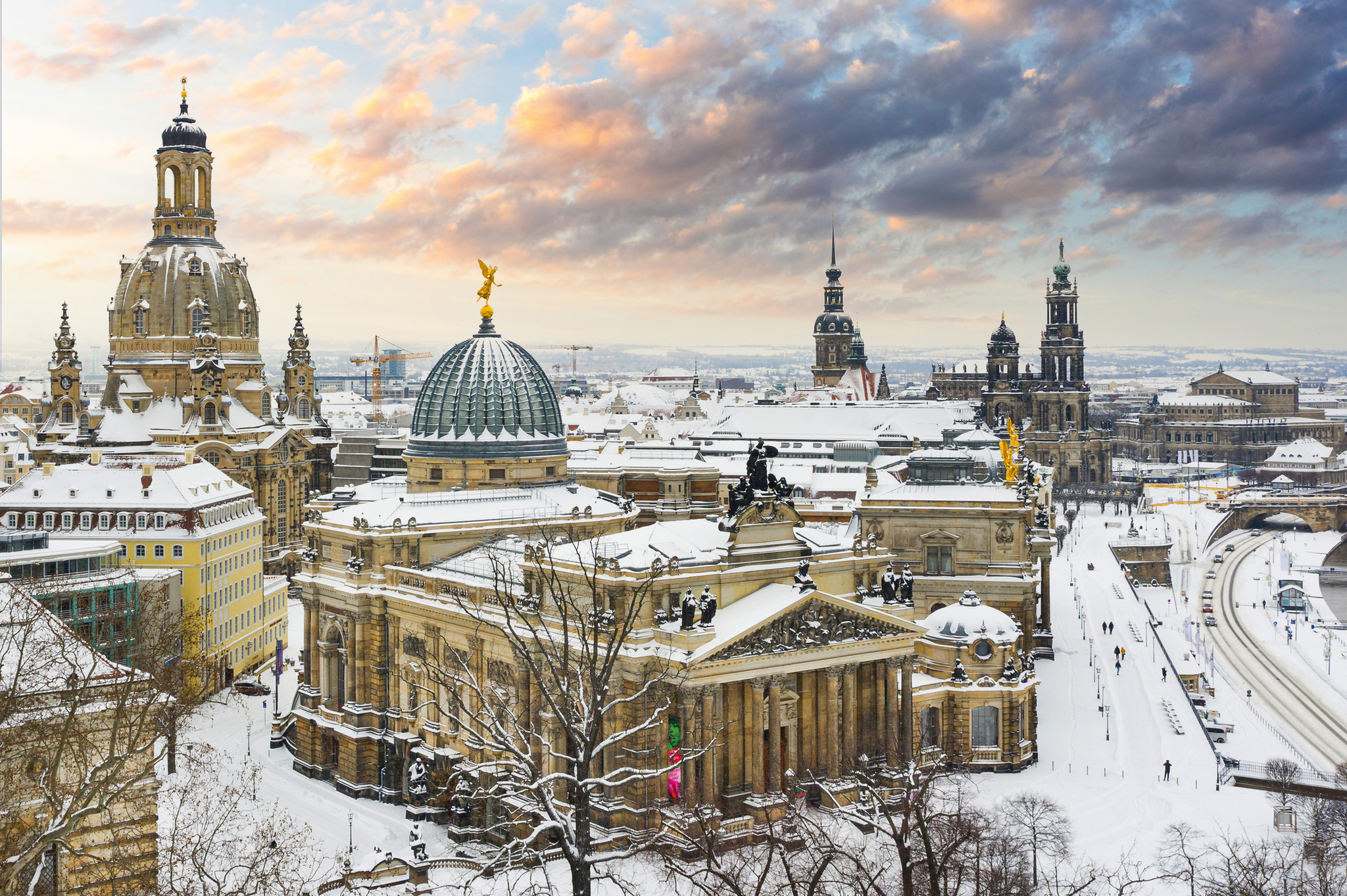 Verschneite Stadtansicht mit historischen Gebäuden bei Sonnenuntergang.
