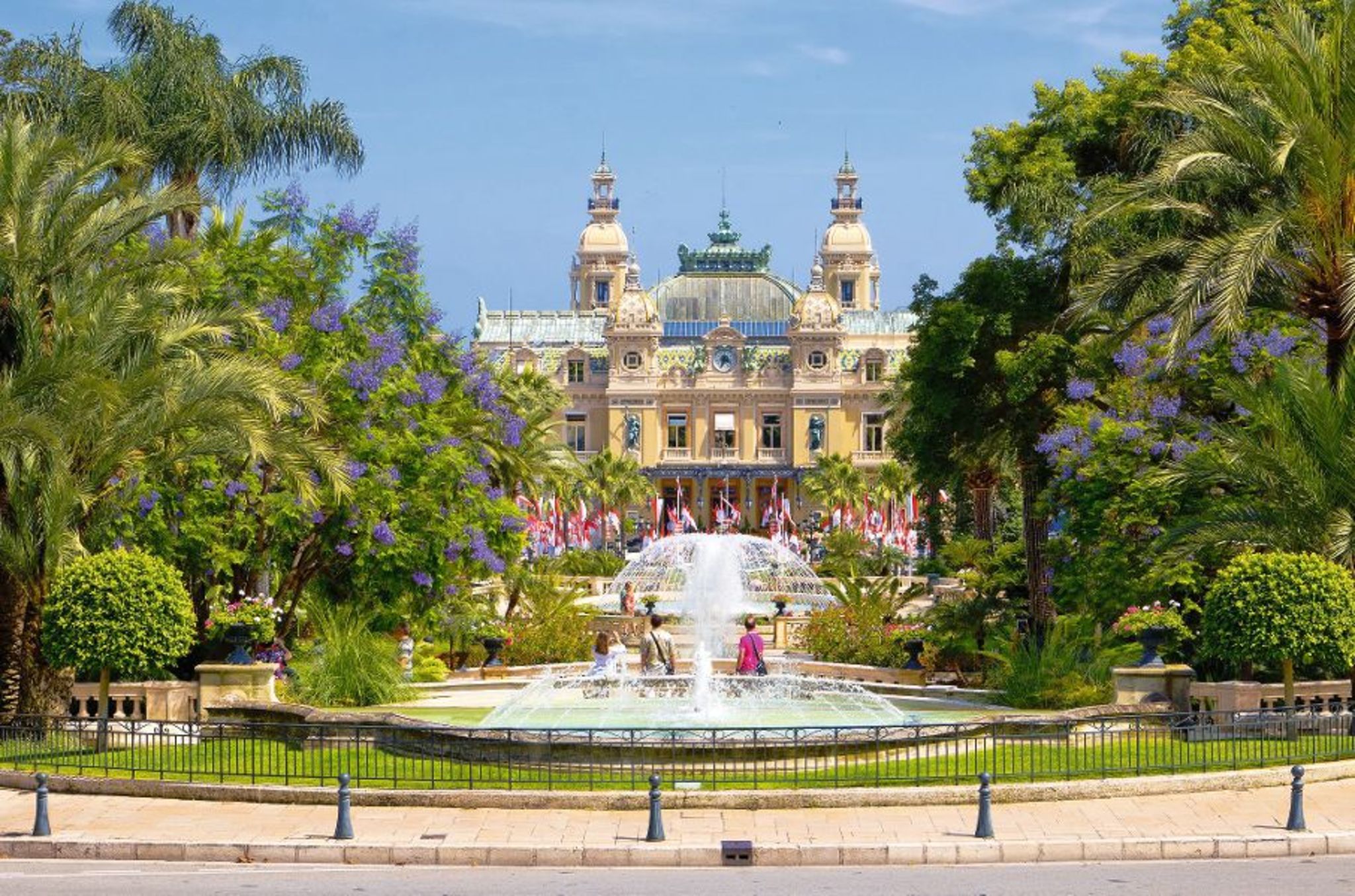 Historisches Gebäude mit Garten und Springbrunnen im Vordergrund.
