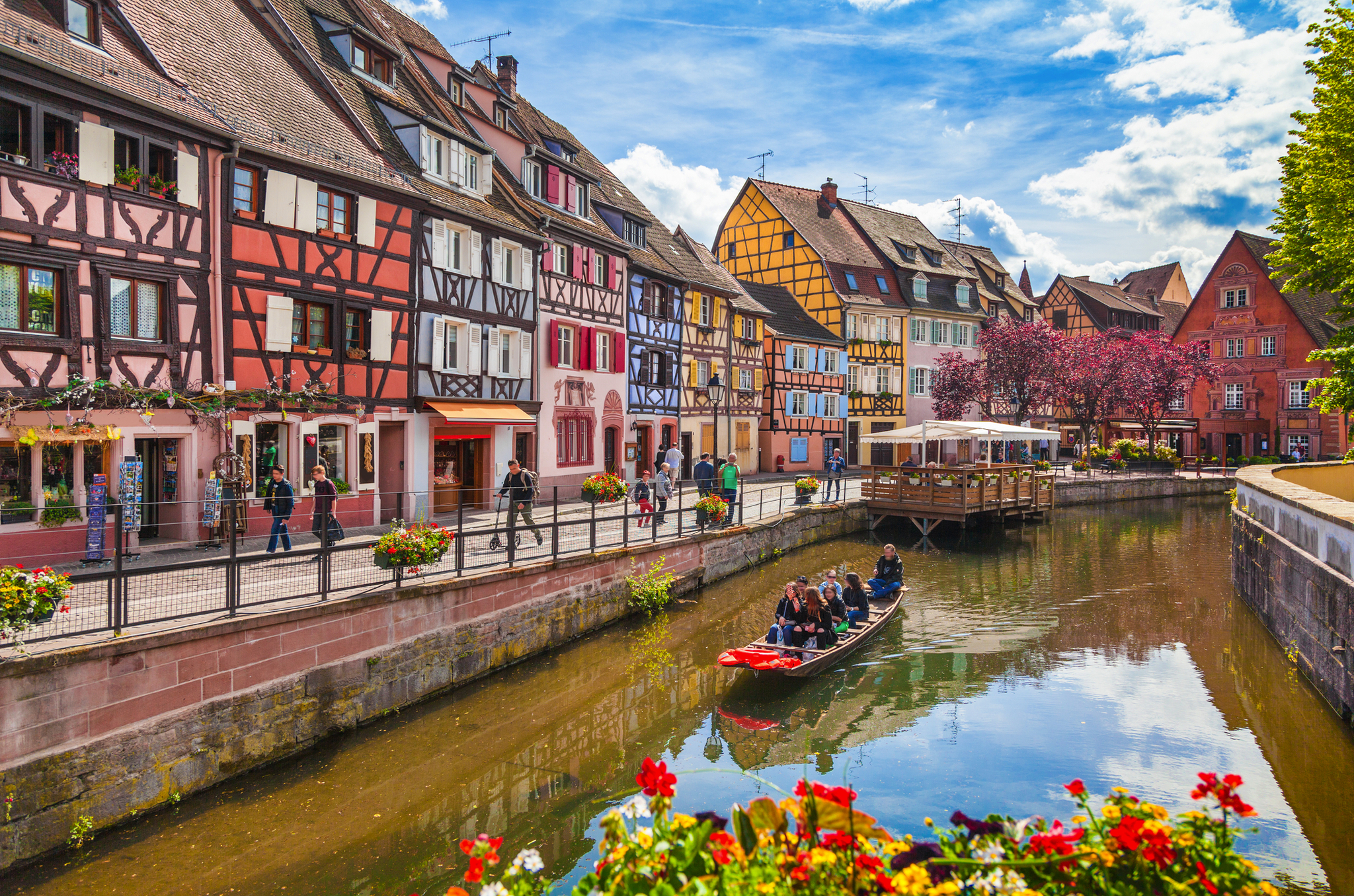 Bunte Fachwerkhäuser und ein Kanal mit Boot in einer europäischen Altstadt.