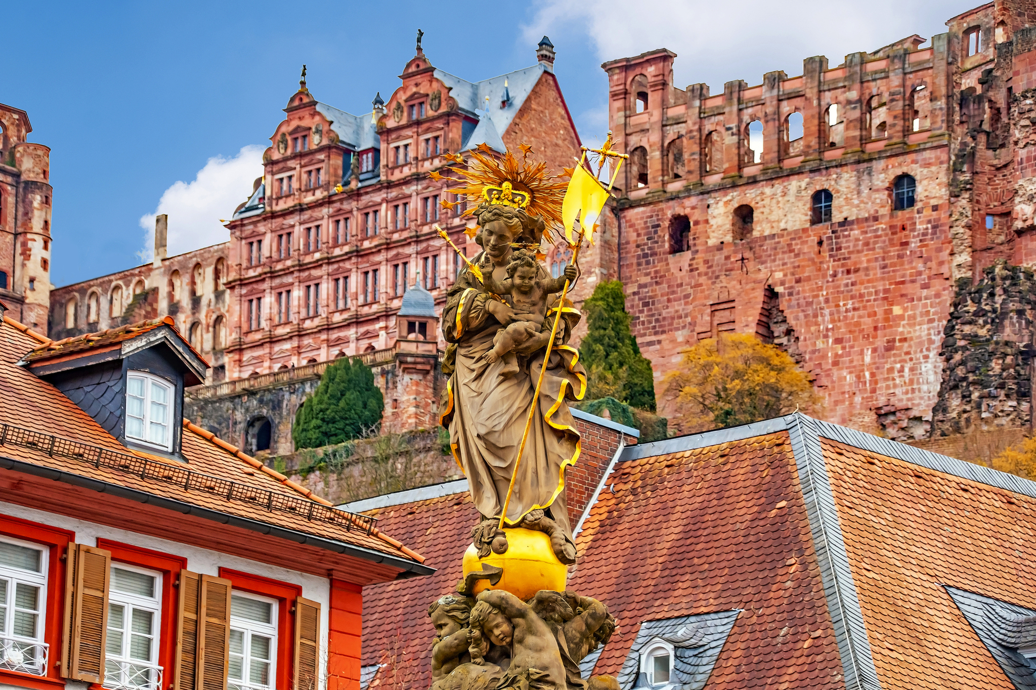 Statue der Madonna mit Kind in der Kornmarkt mit Heidelberger Schloss Statue der Madonna mit Kind auf dem Kornmarkt in Heidelberg vor dem Hintergrund des Heidelberger Schlosses.