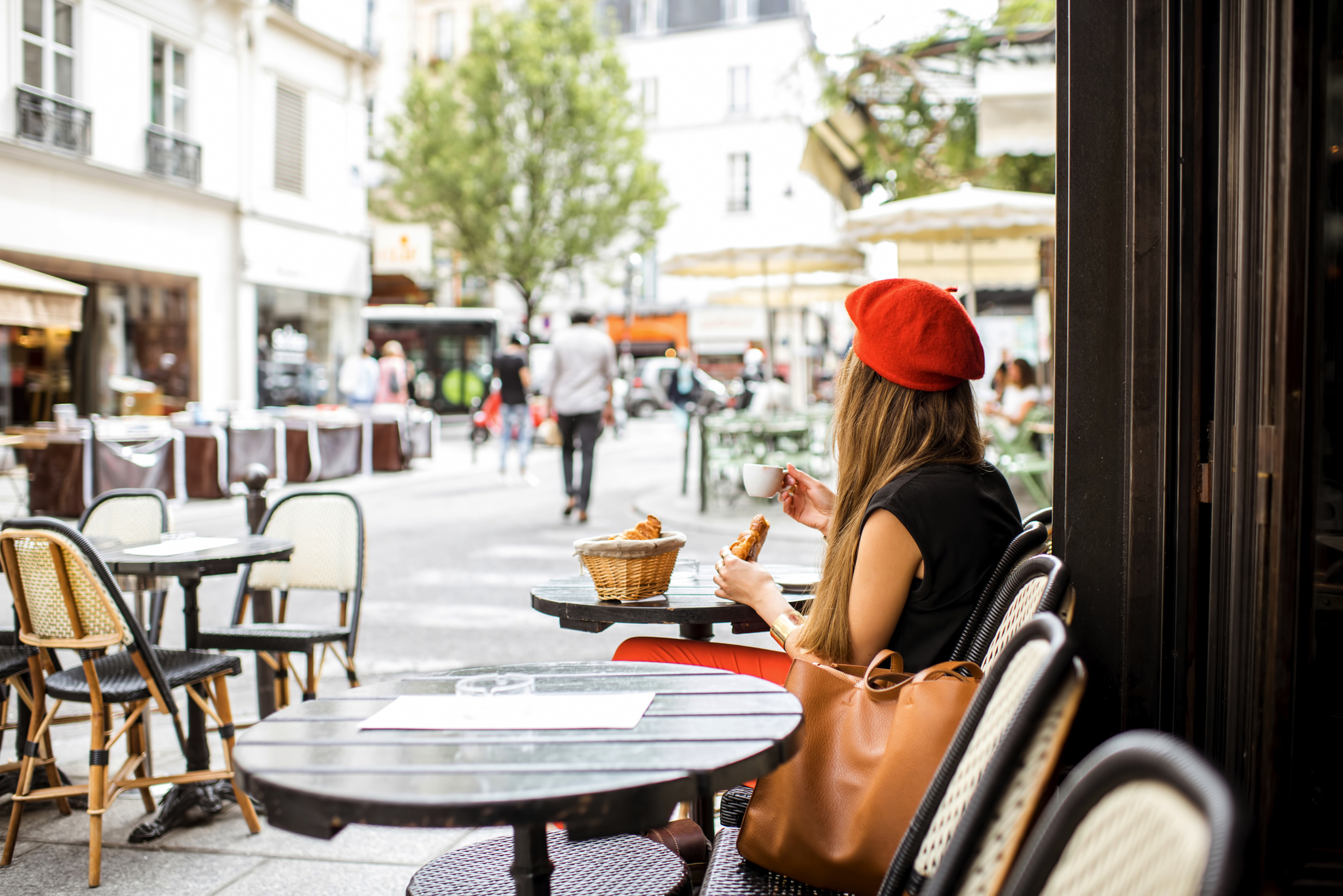 Junge Frau isst ein Croissant in einem Pariser Café.