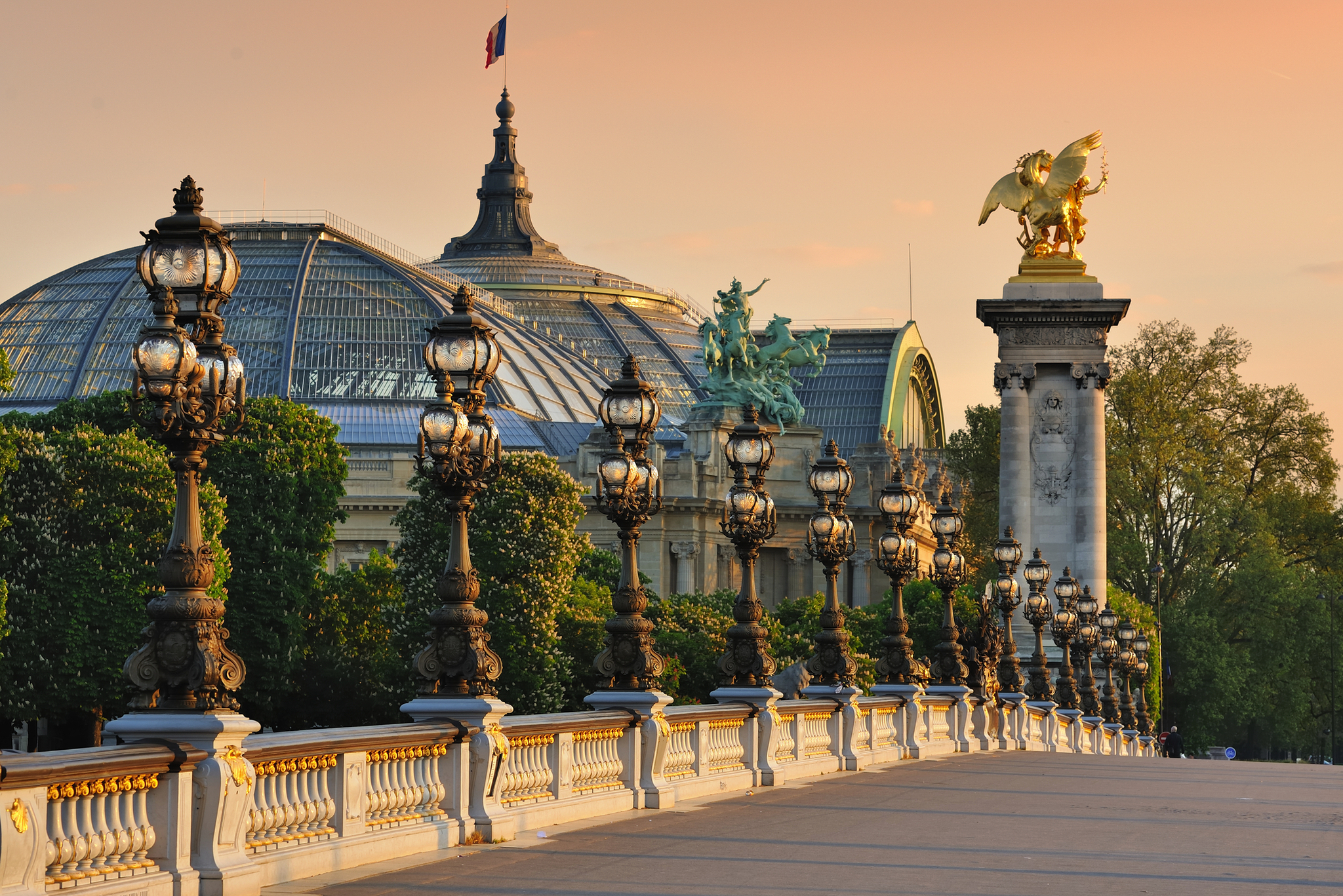Blick auf die Pont Alexandre III in Paris bei Sonnenuntergang mit Grand Palais im Hintergrund.