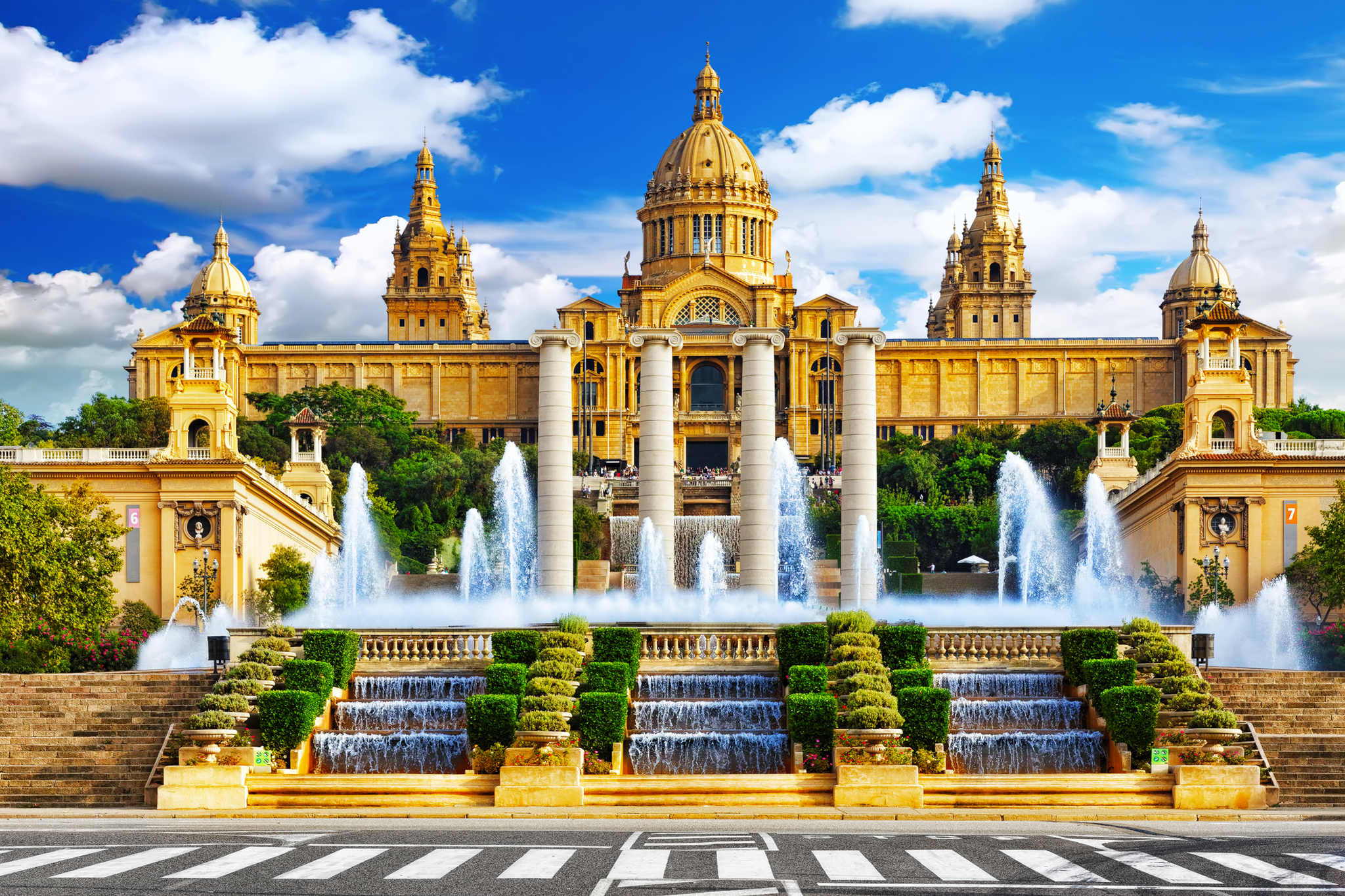 Nationalmuseum in Barcelona Historisches Gebäude mit Brunnen und Treppen vor blauem Himmel.