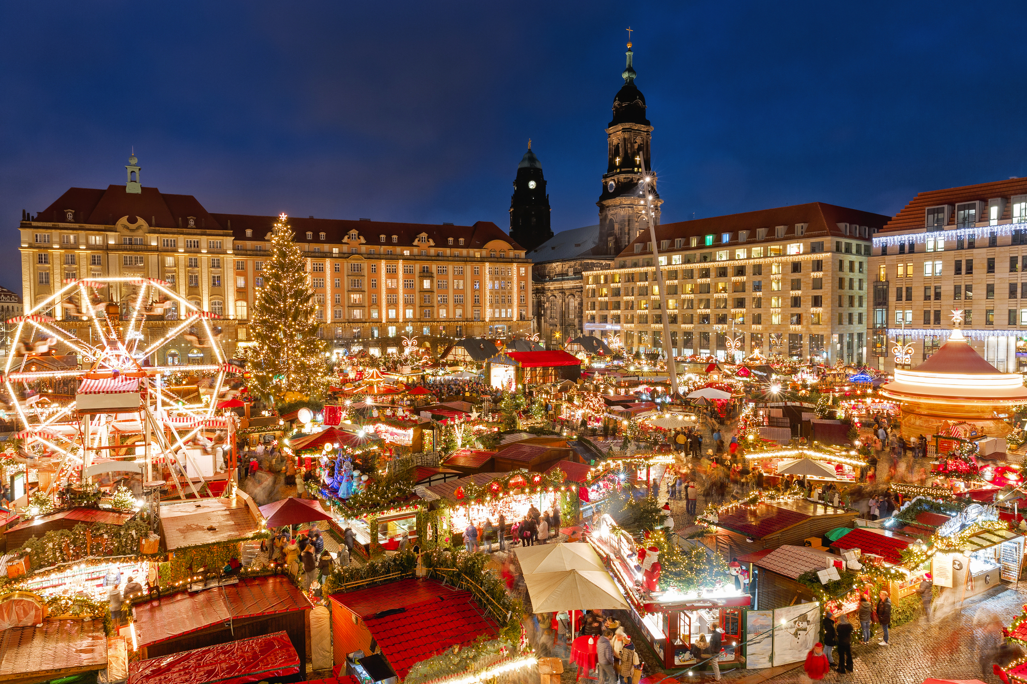 Striezelmarkt auf dem Altmarkt in Dresden, Deutschland Weihnachtsmarkt bei Nacht mit bunten Ständen und Lichtern in einer Stadt.