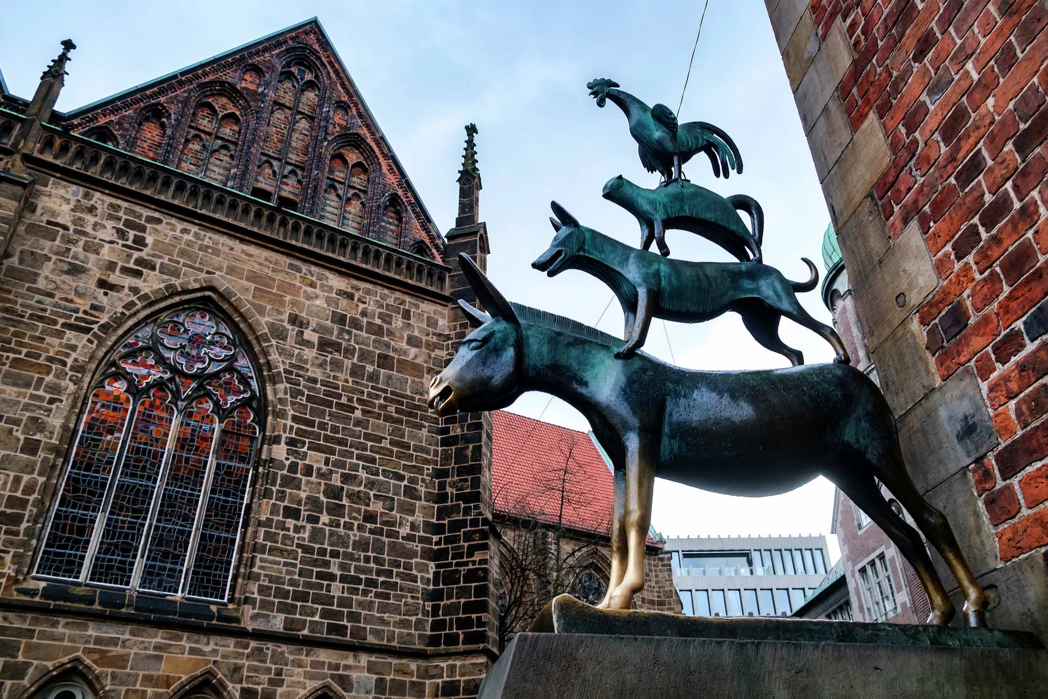 Skulptur der Bremer Stadtmusikanten vor historischer Kirche in Bremen, Deutschland.