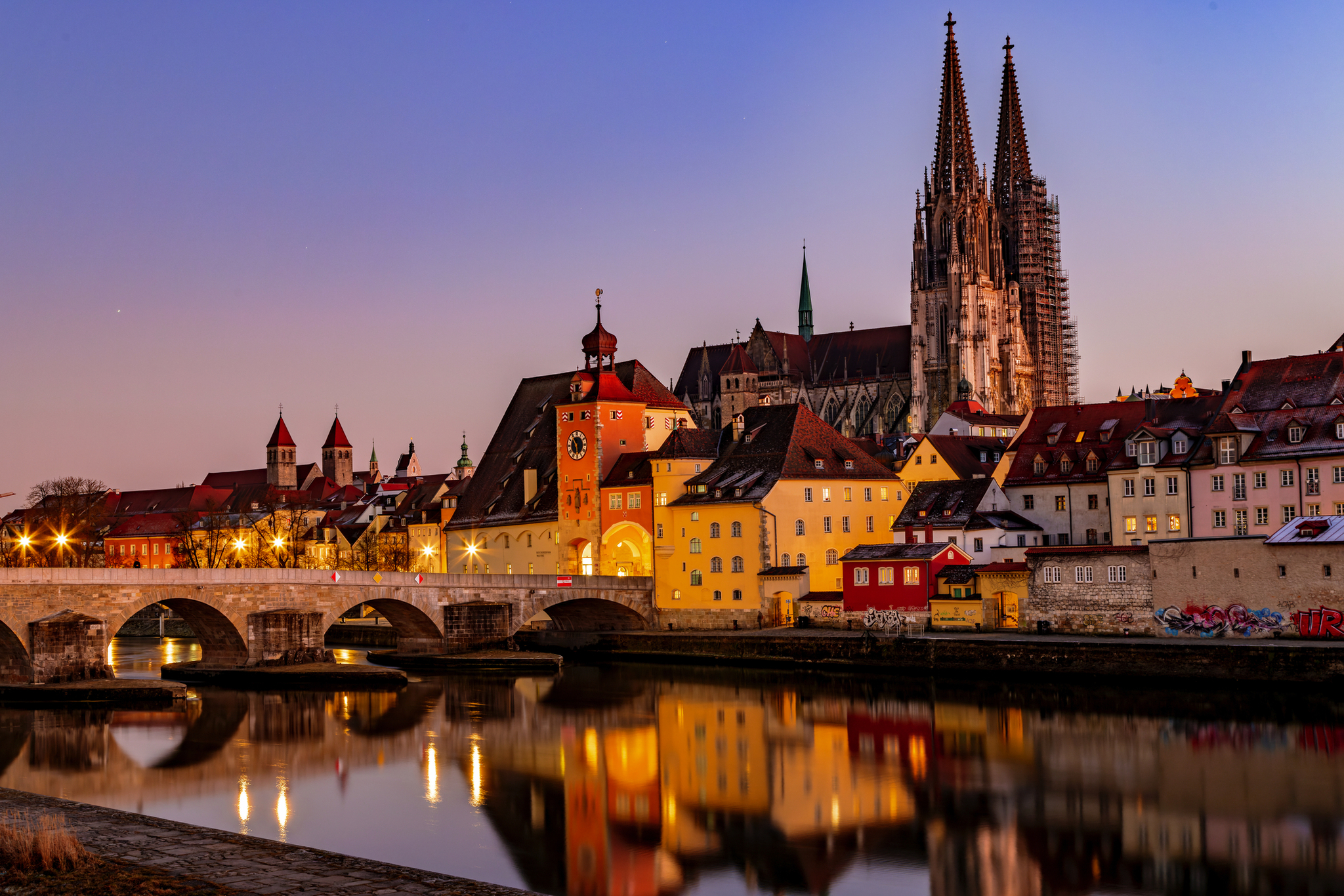 Blick über die Donau auf den Regensburger Dom und die Steinerne Brücke in Regensburg Stadtansicht von Regensburg mit Dom und Steinbrücke am Abend.
