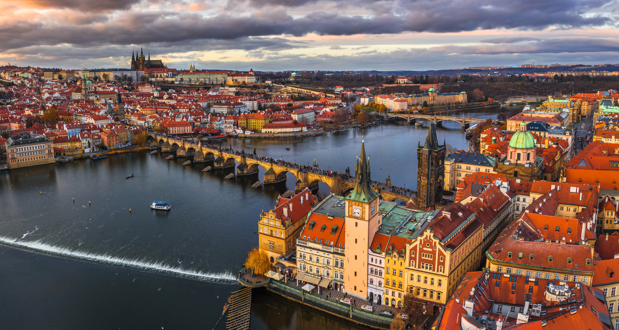 Blick auf die Karlsbrücke und die Stadt Prag bei bewölktem Himmel.