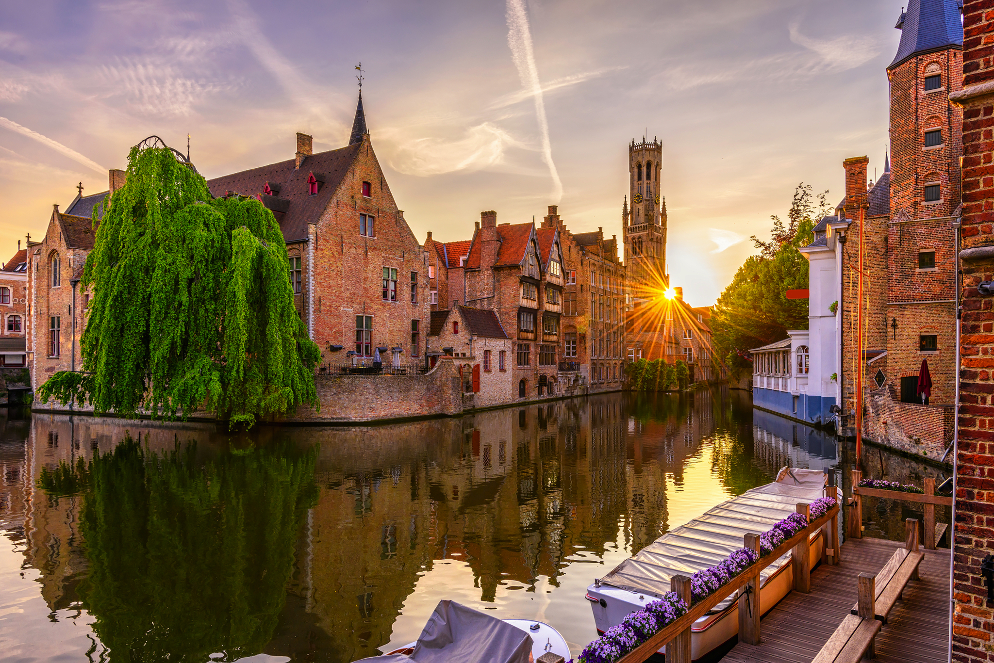 Rozenhoedkaai-Kanal und Belfort-Turm in Brügge Historische Gebäude am Kanal in Brügge bei Sonnenuntergang.