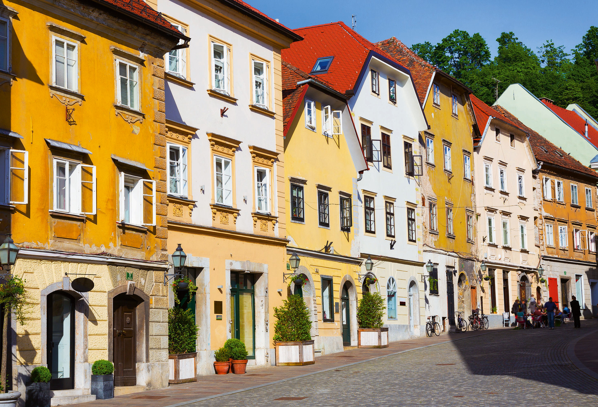 Altstadt von Ljubljana Bunte Häuserreihe an einer gepflasterten Straße bei sonnigem Wetter.