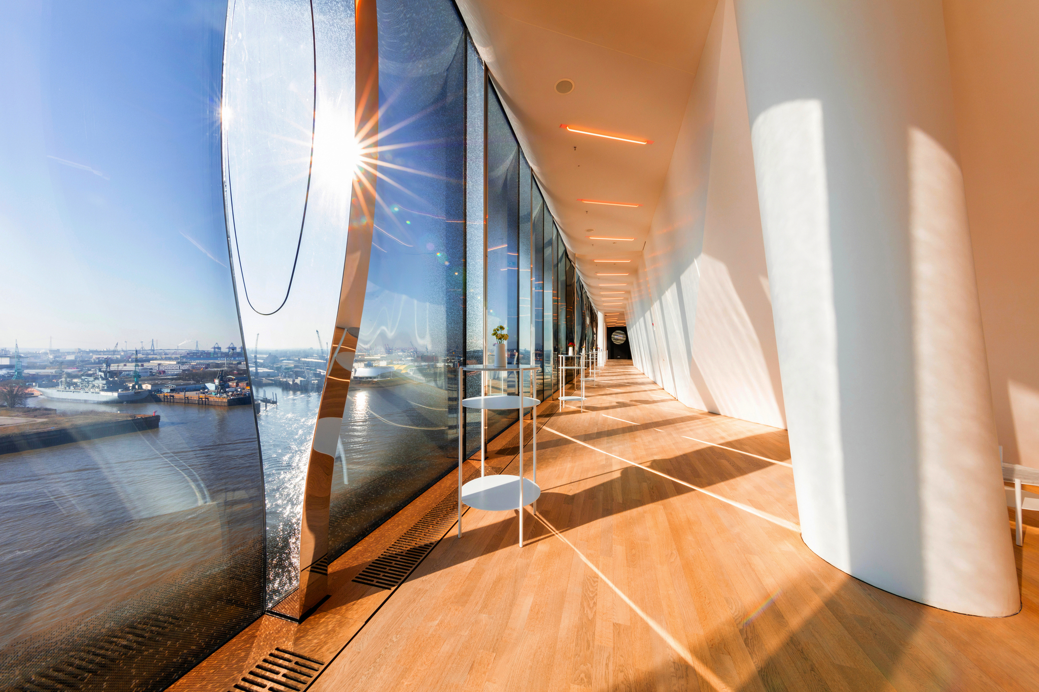 Sonnendurchfluteter Flur in der Elbphilharmonie mit Blick auf den Hafen.