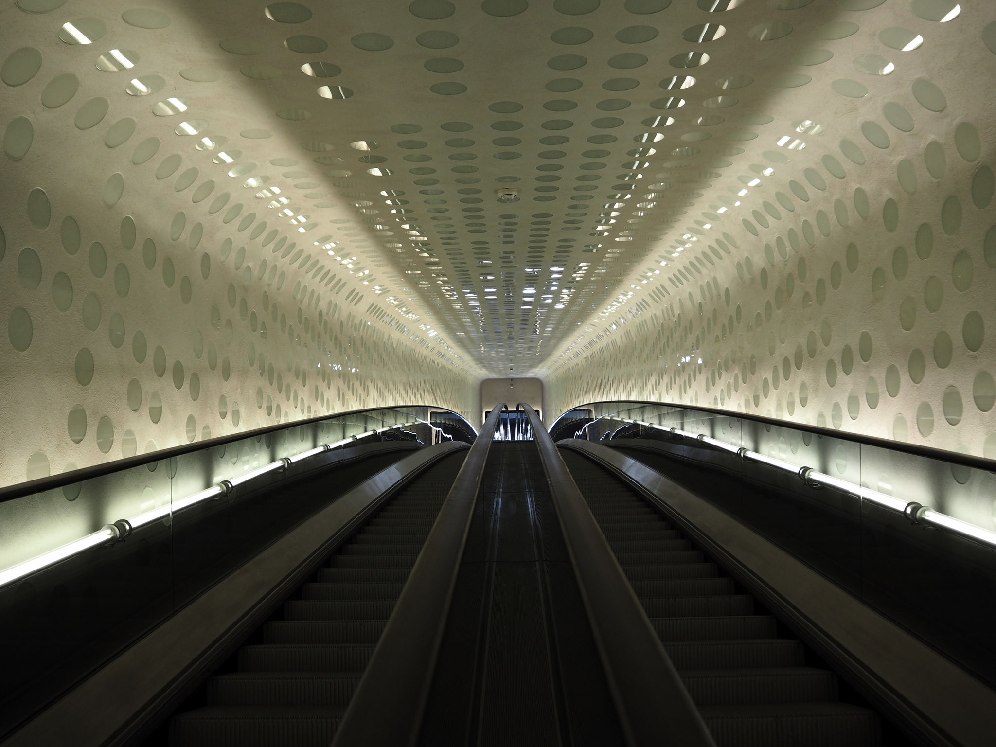 Rolltreppe in modernem Tunnel mit runder Beleuchtung