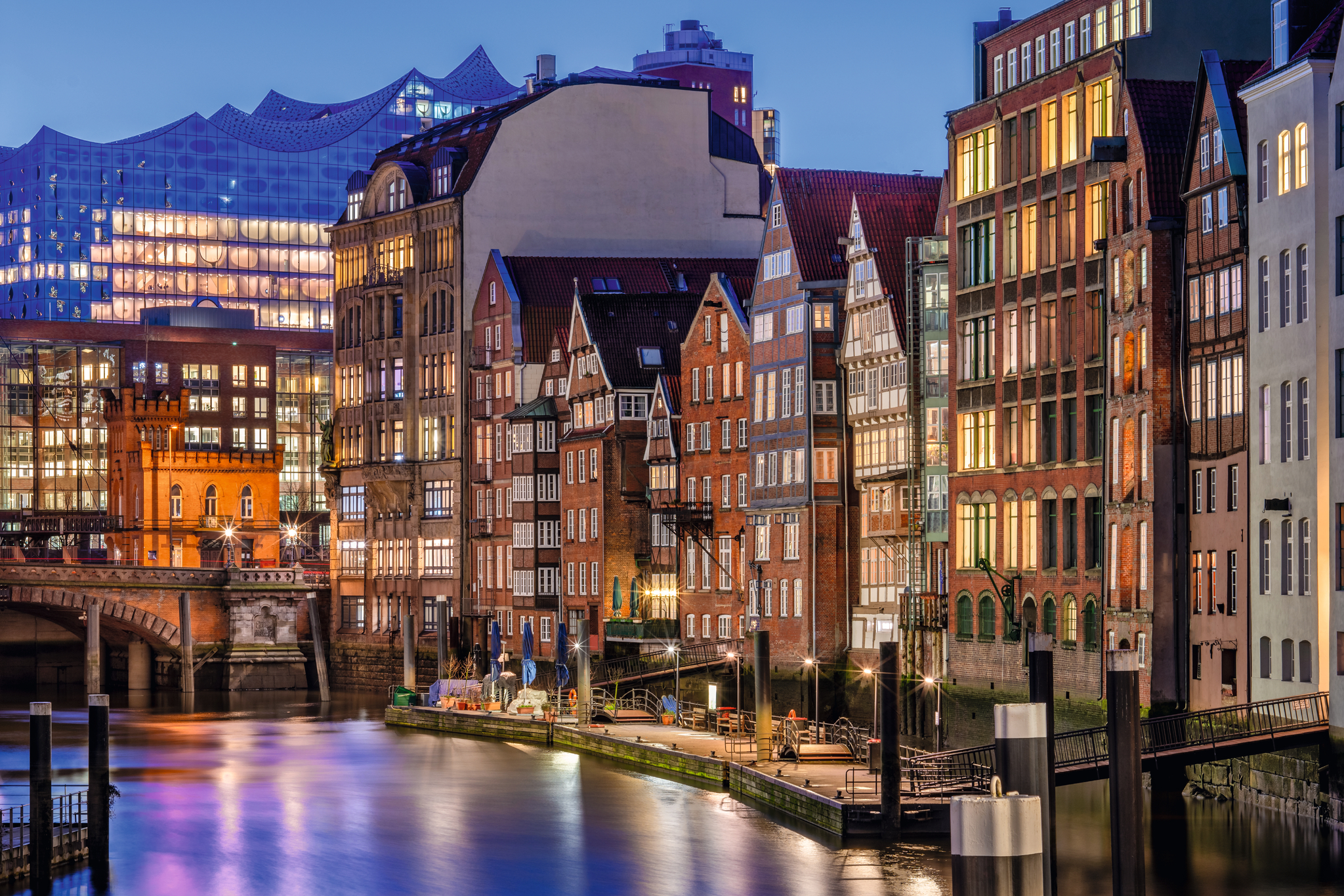 Beleuchtete Häuserfronten an einem Kanal in der Abenddämmerung.