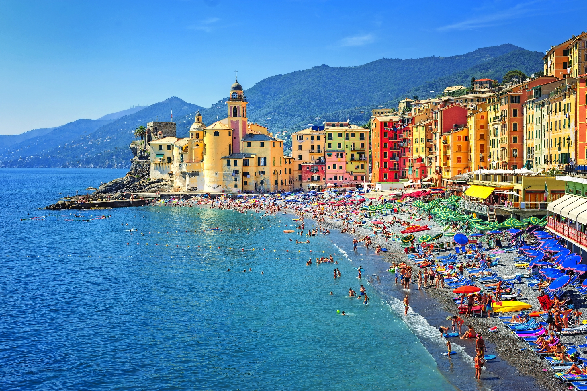 Sandstrand in Camogli von Genua, Italien Bunte Küstenstadt mit Strand, zahlreichen Badenden und bunten Sonnenschirmen.
