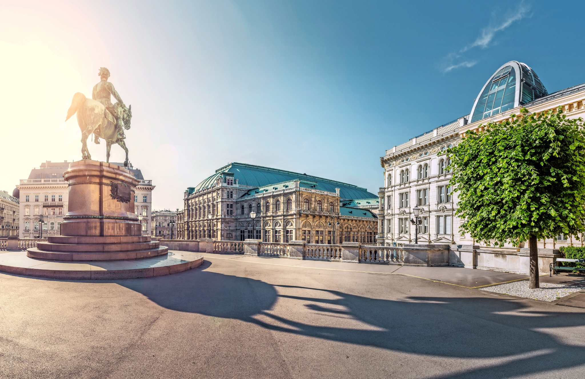 Wiener Staatsoper am Heldenplatz in Wien Reiterstatue auf großem Platz vor historischen Gebäuden bei Sonnenschein.