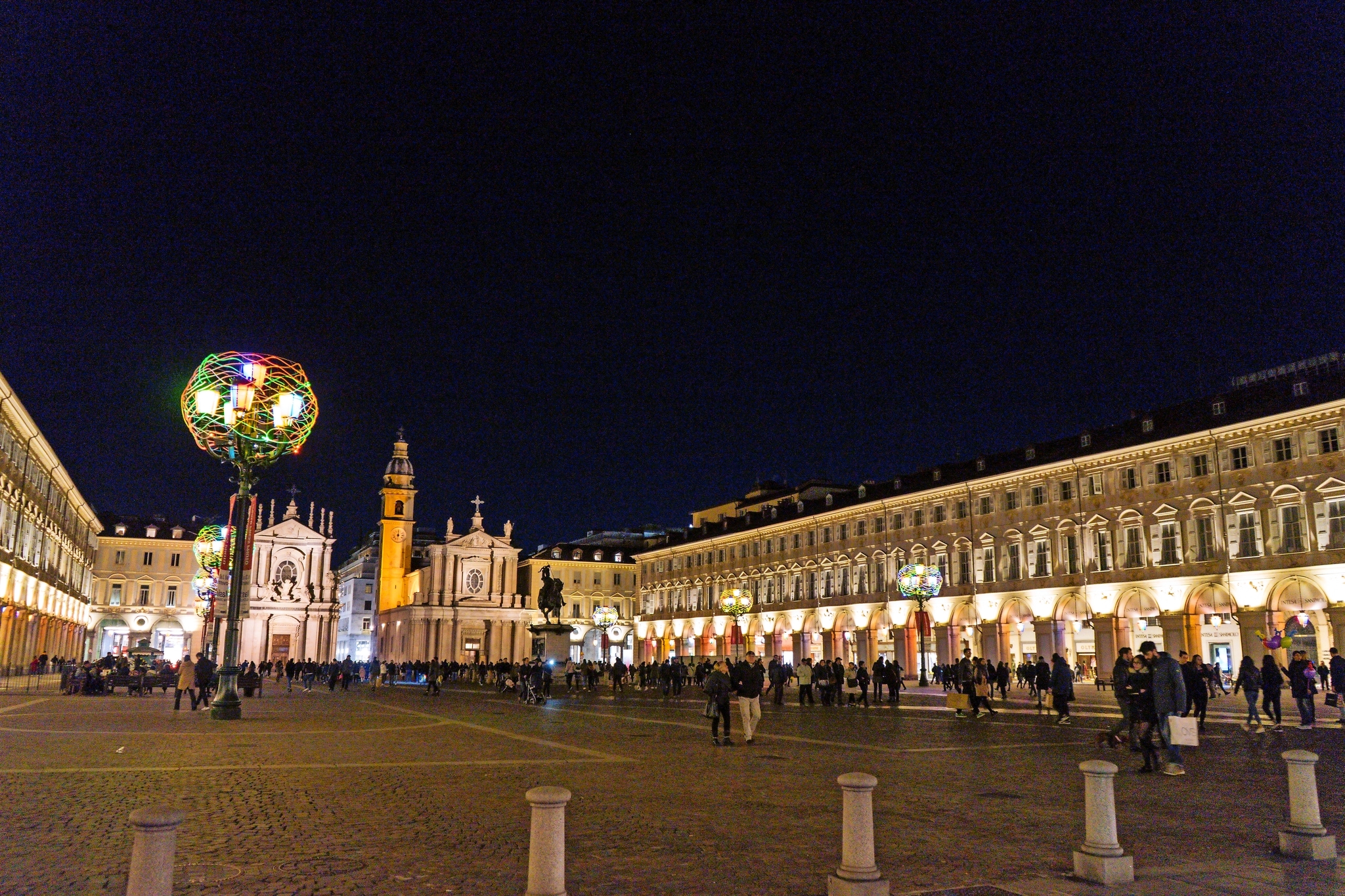 Nachtansicht von Piazza San Carlo in Turin Nächtlicher Platz mit beleuchteten Gebäuden und Menschenansammlung.