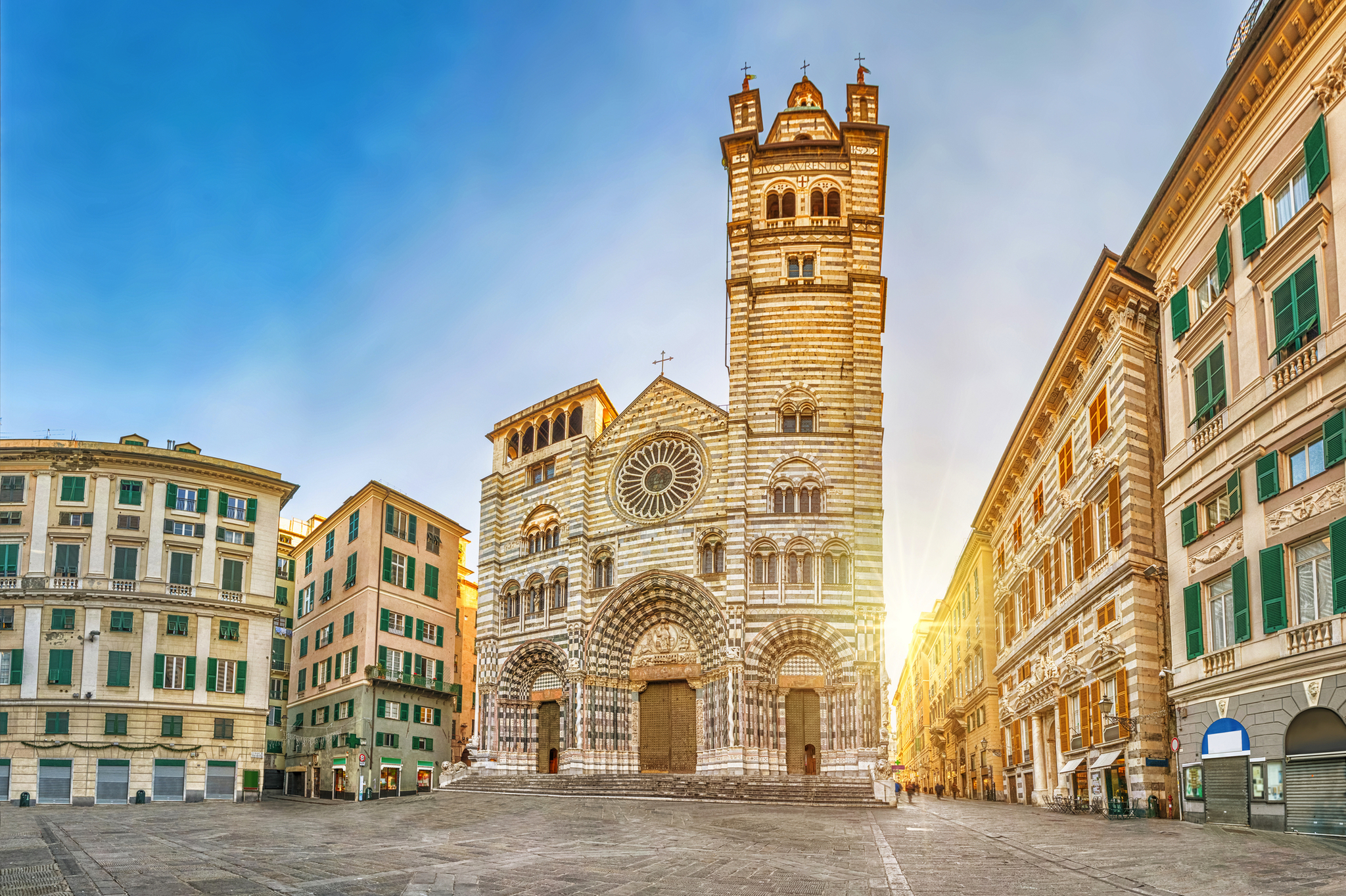 Kathedrale San Lorenzo Historische Kathedrale mit weißen und grauen Streifen auf einem leeren Platz bei Sonnenuntergang.
